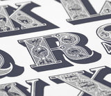 Close up of illustrated A-Z screen print wall art in slate grey